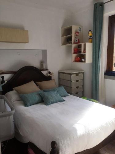 a bedroom with a large white bed with blue pillows at Casa da Âncora in Colares