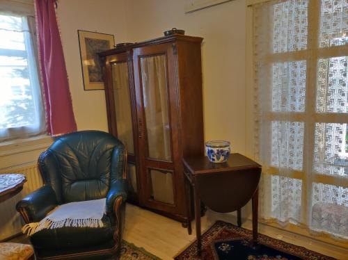 a living room with a chair and a cabinet at Guest room in Transylvania in Vlaha