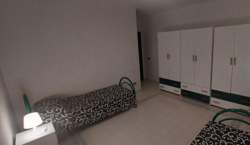 a bedroom with a bed and white cabinets at Villa con giardino sul lungomare in Campofelice di Roccella