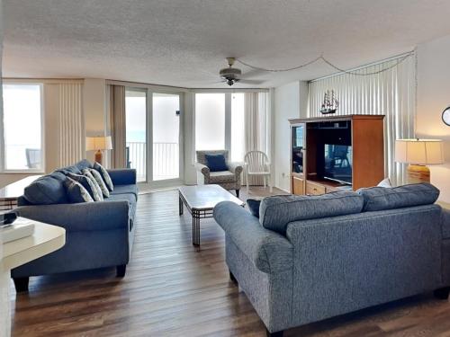 a living room with two couches and a television at Shores Club 807 in Daytona Beach