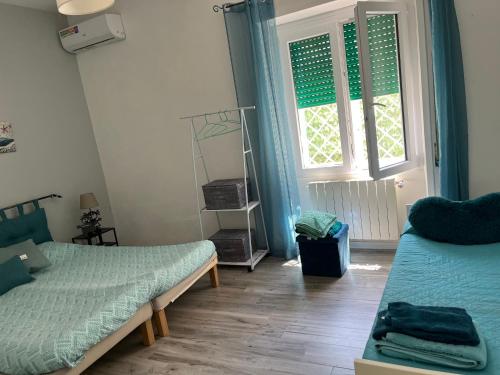 a bedroom with two beds and a window at Aria di Mare in Lido di Ostia