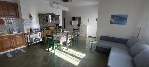 a living room with a couch and a table at Villa con giardino sul lungomare in Campofelice di Roccella