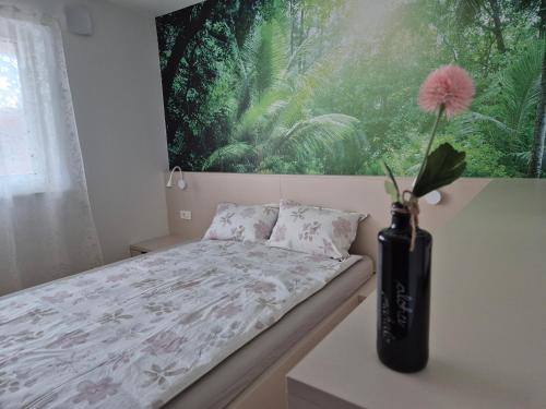 a bedroom with a bed and a vase with a flower at TaWorld apartment in Šmartno pri Litiji