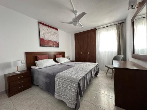 a bedroom with a bed and a table and a desk at BENIDORM SKYLiNE in Benidorm