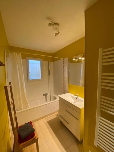 une salle de bain avec une baignoire et un lavabo et une baignoire dans l'établissement Gîte les Clairieres - Piscine, Climatisation, à Cauzac