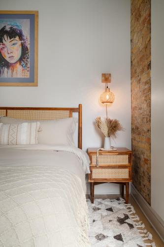 a bedroom with a bed and a table with a lamp at Ace Properties in Chicago