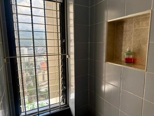 a bathroom with a window with a view of a city at Apartaestudios - Torre de Cali in Cali