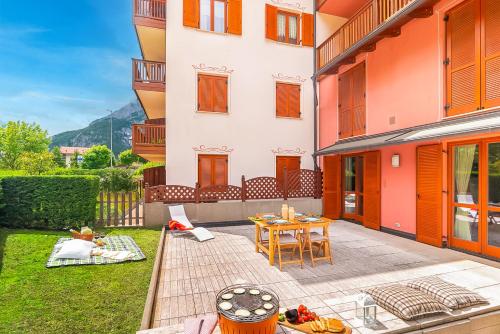a patio of a building with a table and chairs at Giardino sul Lago - Vista su lago e montagne a Molveno in Molveno