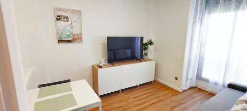 ein Wohnzimmer mit einem Flachbild-TV auf einem Schrank in der Unterkunft Apartamento Aeropuerto Suite 2 2 3 E in Madrid