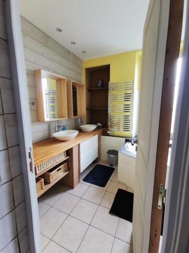 une salle de bain avec deux lavabos et deux miroirs dans l'établissement Maison proche de la Loire, à Saint-Florent-le-Vieil