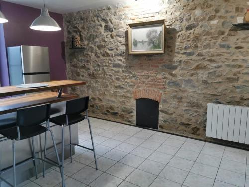 Il comprend une cuisine dotée d'un mur en briques et d'une cheminée. dans l'établissement Maison proche de la Loire, à Saint-Florent-le-Vieil