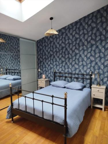 une chambre avec deux lits et un mur noir et gris dans l'établissement Maison proche de la Loire, à Saint-Florent-le-Vieil