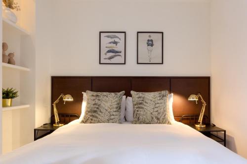 a bedroom with a large white bed with two lamps at Modern Carnaby Soho 1BR Apartment with AC in London