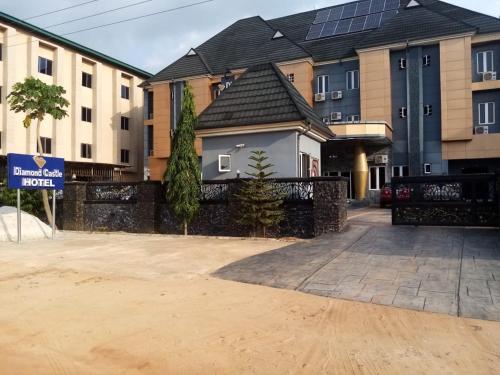 a house with a fence in front of some buildings at Diamond castle Hotel in Mama
