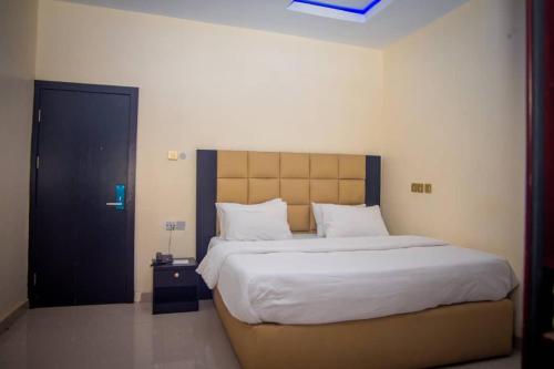 a bedroom with a large bed with white sheets and pillows at Diamond castle Hotel in Mama