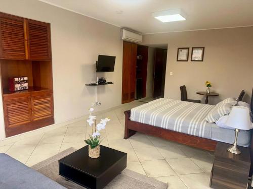 a bedroom with a bed and a table with flowers on it at Apartaestudios - Torre de Cali in Cali