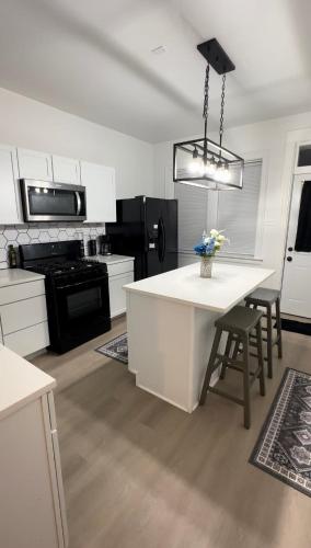 a kitchen with white cabinets and a table with chairs at Cozy Casa by OHare Airport in Chicago