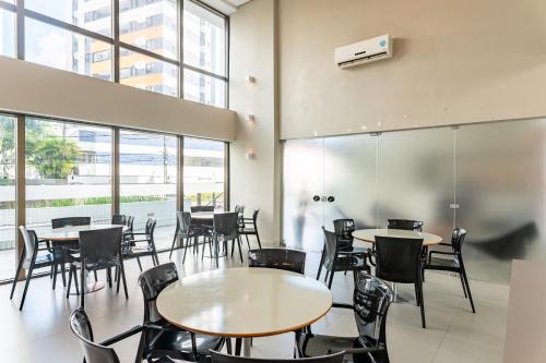 a restaurant with tables and chairs and windows at Flat 701 - PortoMar Home Club in Recife