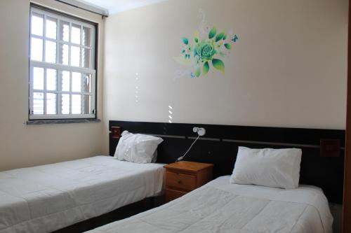 a room with two beds and a clock on the wall at AL Novavista by A5P in Madalena