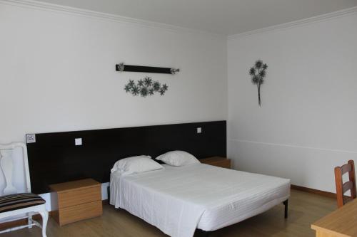 a bedroom with a white bed with a black headboard at AL Novavista by A5P in Madalena