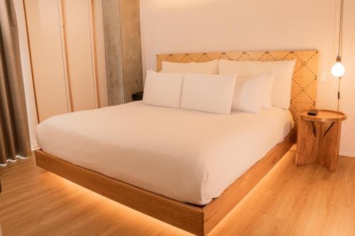 a bed with white sheets and pillows in a room at Topá House in Medellín