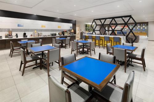 a dining room with tables and chairs in a restaurant at GLō Best Western Tulsa-Catoosa East Route 66 in Catoosa