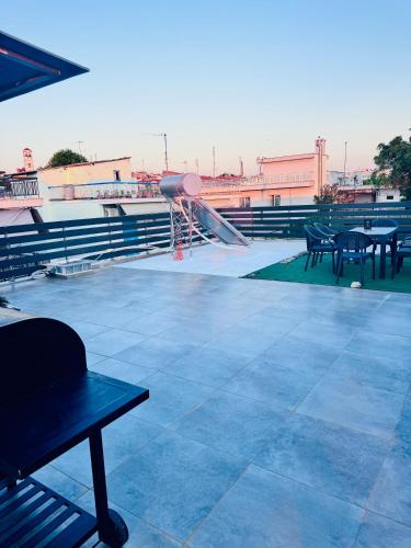 a rooftop patio with tables and a basketball hoop at Modern Grey in Néa Michanióna
