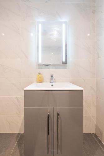 a bathroom with a white sink and a mirror at 1 Bedroom Luxury Serviced Apartment in Bradford