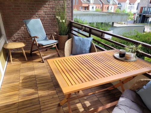 patio con mesa de madera y sillas en el balcón en Waldstraße 2 Windrose Kellenhusen, en Kellenhusen