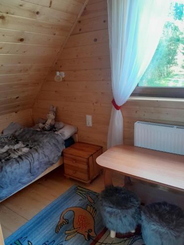 a bedroom with a bed and a window in a log cabin at Domek w dolinie ciszy Pieniny in Grywałd
