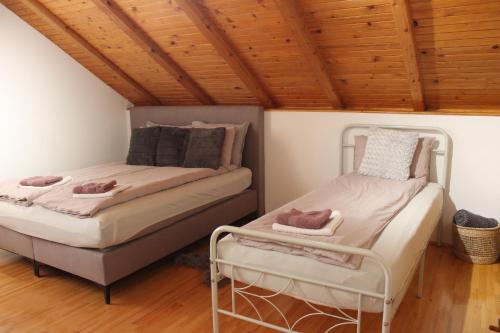 two beds in a room with a wooden ceiling at Villa Solis in Sarajevo