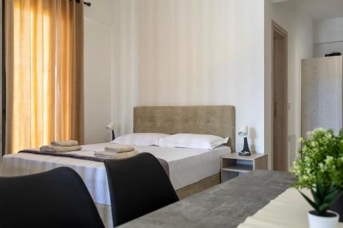 a bedroom with a bed and a table with chairs at NS Apartments Nydri in Nydri