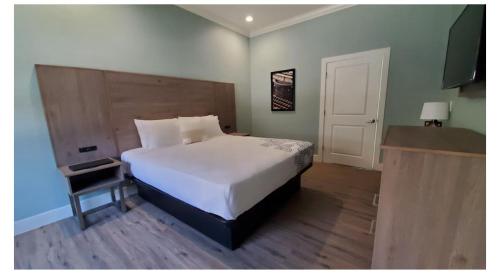 a bedroom with a large white bed and a door at Crestridge Inn Near LAX, SoFi Stadium & Intuit Dome in Inglewood