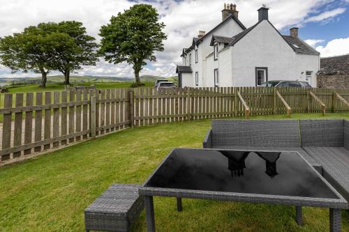 a table with two cows on it in front of a house at Dunallan Farm Cottage with Optional Hot Tub & Stunning Views in Island of Bute