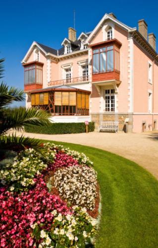 a large house with flowers in front of it at Plat Gousset - RDC in Granville