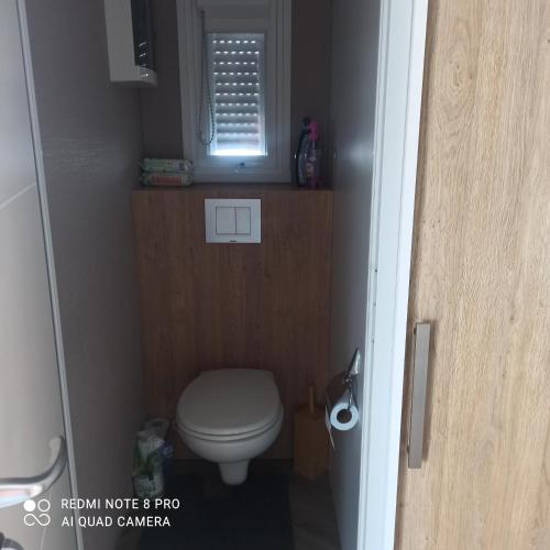 Elle comprend une petite salle de bains pourvue de toilettes et d'une fenêtre. dans l'établissement Résidence Camping Les Dunes, au Grau-dʼAgde