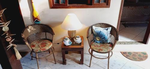 a room with two chairs and a table with a lamp at Pousada Horizonte dos Borbas in Abraão