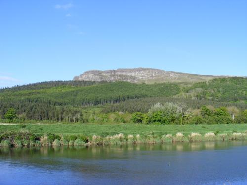 a view of a river with a mountain in the background at Swanns Bridge Glamping in Limavady