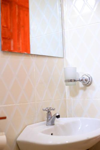 a bathroom with a white sink and a mirror at Kisoro Comfort Inn in Kisoro