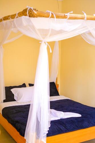 a bedroom with a bed with a canopy at Kisoro Comfort Inn in Kisoro
