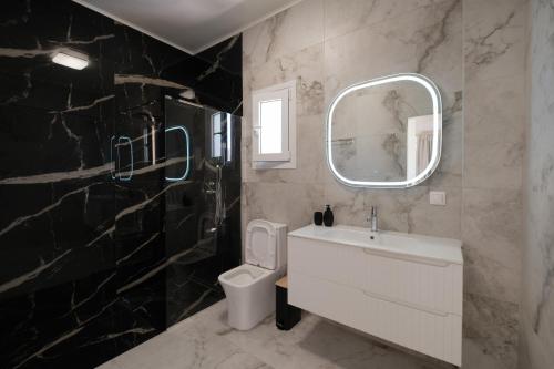 a bathroom with a white sink and a mirror at Natural Blue Suites-Canal d'Amour Retreat in Sidari