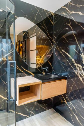 a bathroom with a sink and a mirror at Boshuisje Seth sauna en whirlpool in Appelscha