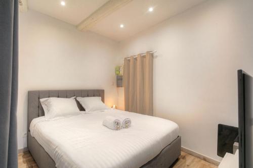 a bedroom with a large white bed with two shoes on it at Beautiful bright apartment - Near Fourvière in Lyon