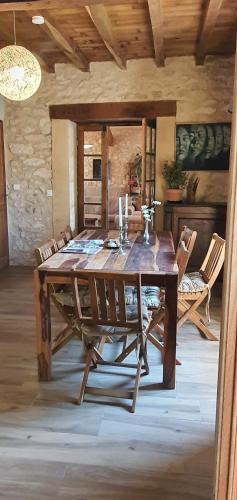 une salle à manger avec une table et des chaises en bois dans l'établissement Maison de campagne avec bain nordique, à Monflanquin