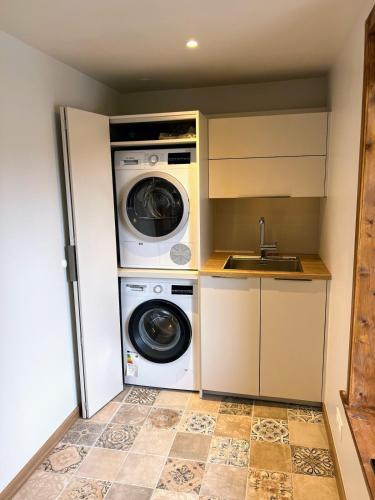 a kitchen with a washing machine and a sink at Chalet Tomsine in Samoëns