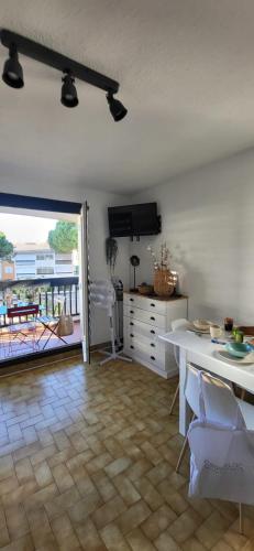 d'un salon avec une table et un balcon. dans l'établissement Camargue Village 2 Clim Balcon, au Grau-du-Roi