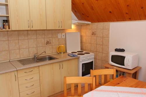 a kitchen with a sink and a stove and a microwave at Chata Bielo in Liptovský Ján