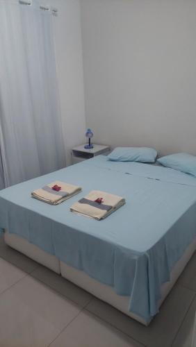 a bed with two towels on top of it at Apartamento Campos dos Goytacazes de 3 quartos com ar condicionado in Campos dos Goytacazes