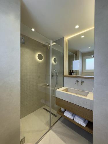 a bathroom with a sink and a shower at Palm Boutique Suites in Pefkohori