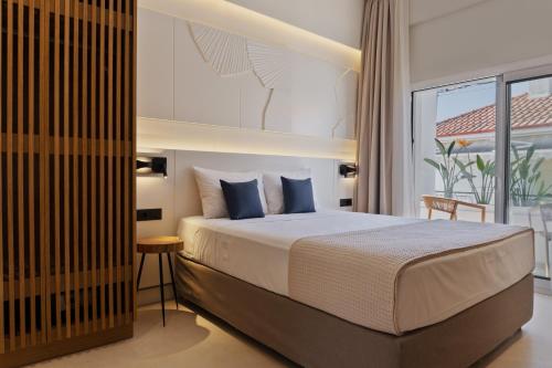 a bedroom with a large bed and a balcony at Palm Boutique Suites in Pefkohori